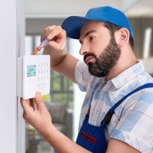 Professional installing an alarm system. 