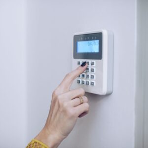 a person putting a code into a wall security system