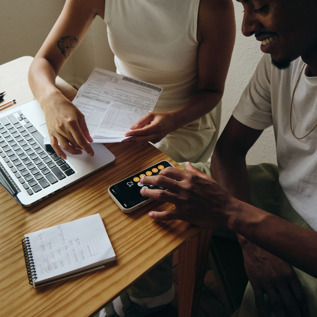 couple happy calculating finances at table