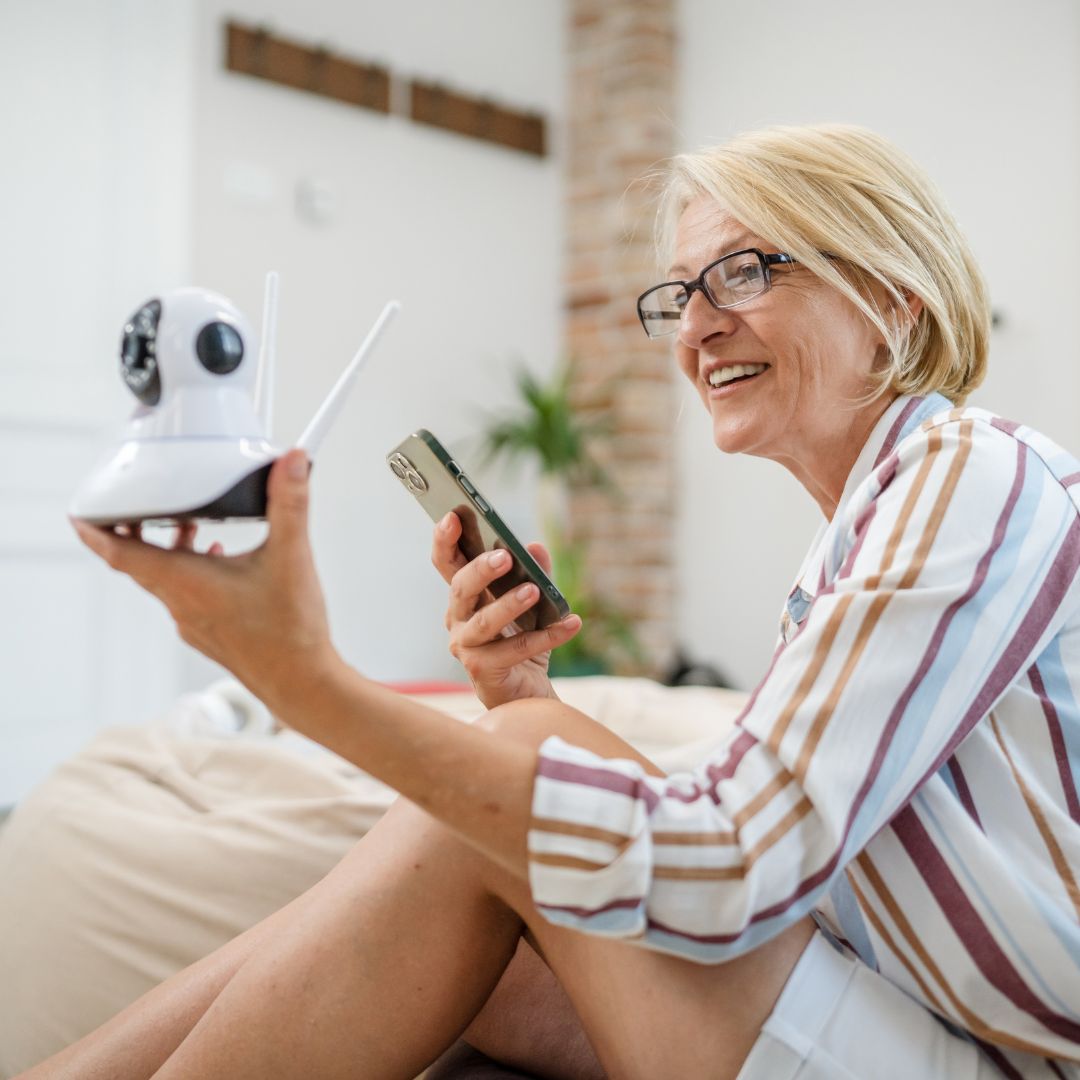 woman holding security camera,, setting it up on phone
