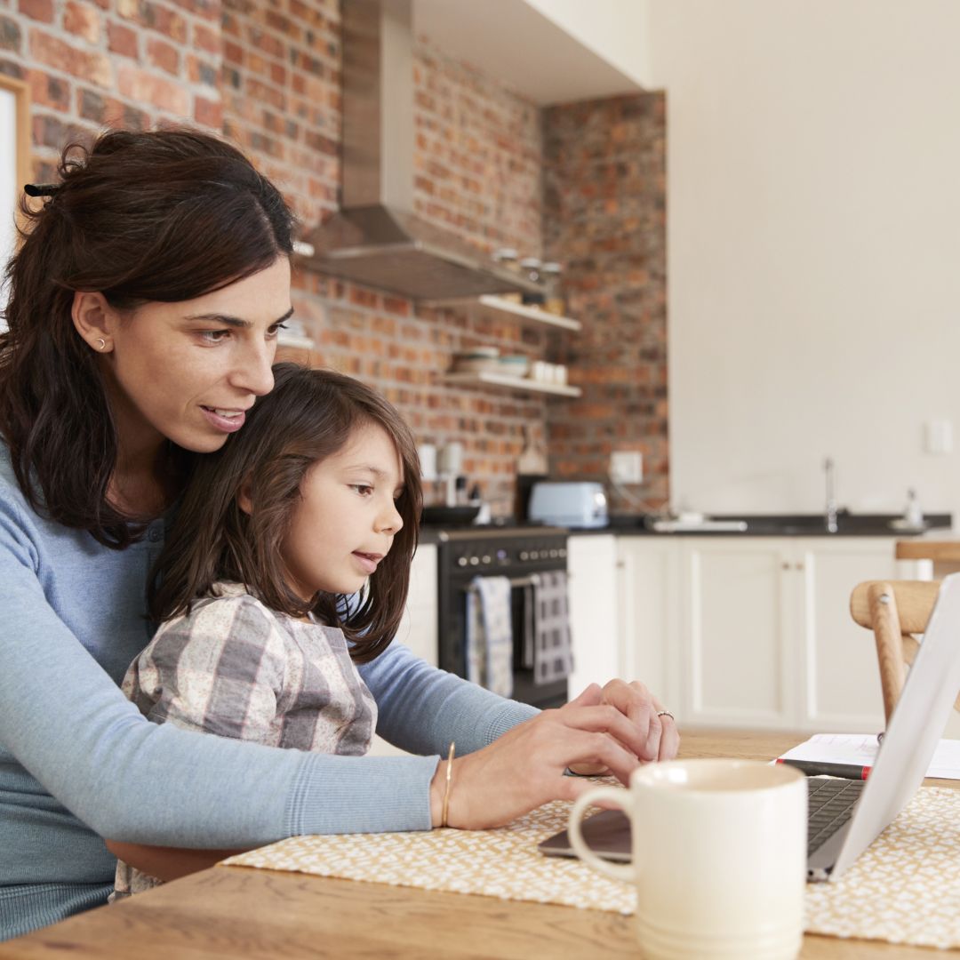 mom and daughter looking at their computer