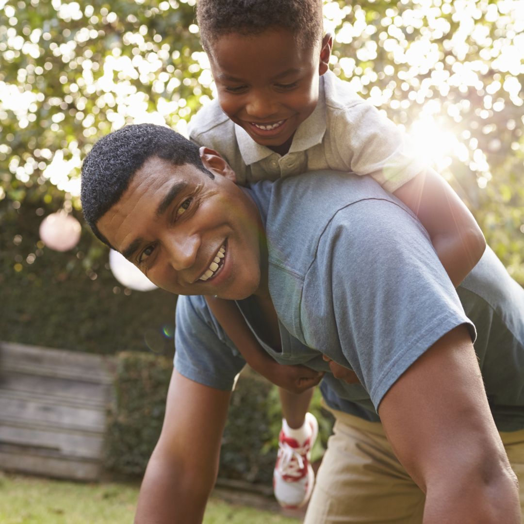 dad carrying son on his back